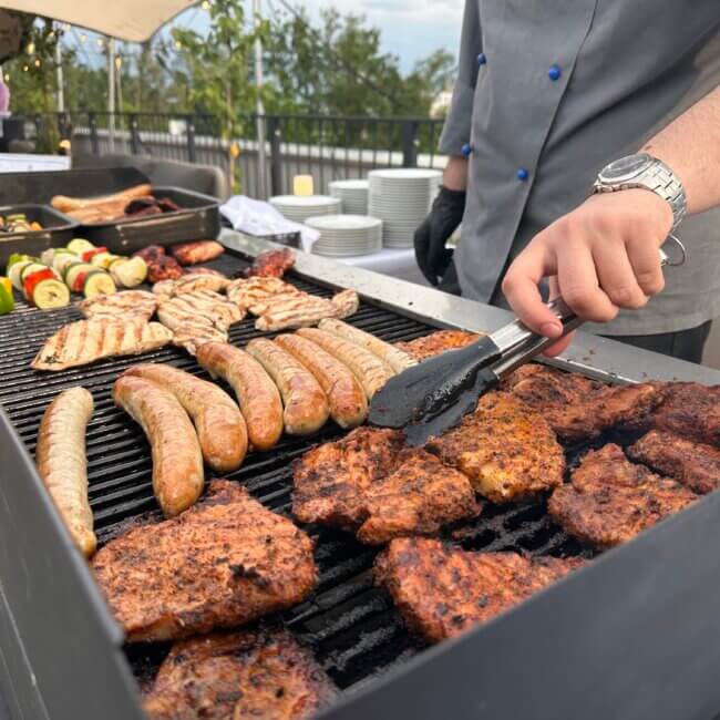 Der Koch, der Fleisch auf einem Grill zubereitet.