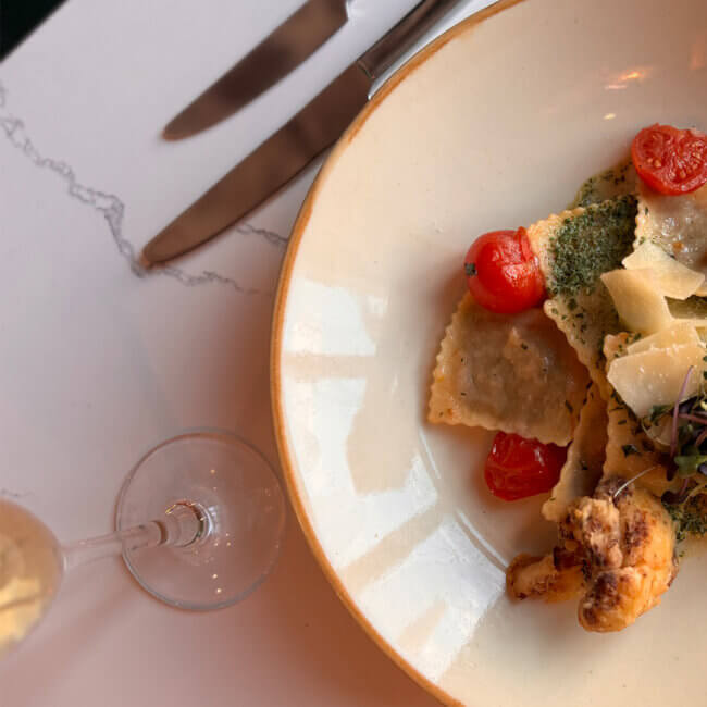 Ravioli mit frischem Gemüse und ein Glas Sekt
